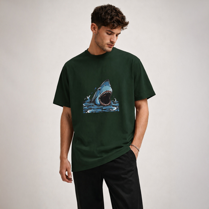 Man wearing a green t-shirt with a shark graphic on a plain background