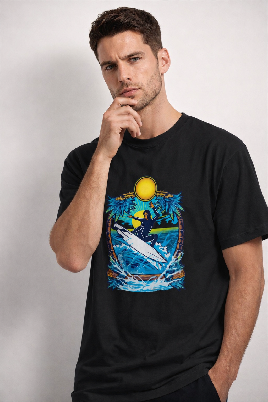 Man wearing a black t-shirt with a graphic design of a person surfing on a wave.