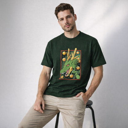 Man wearing a green t-shirt with a graphic design of a dragon and flowers, sitting on a stool against a white background.