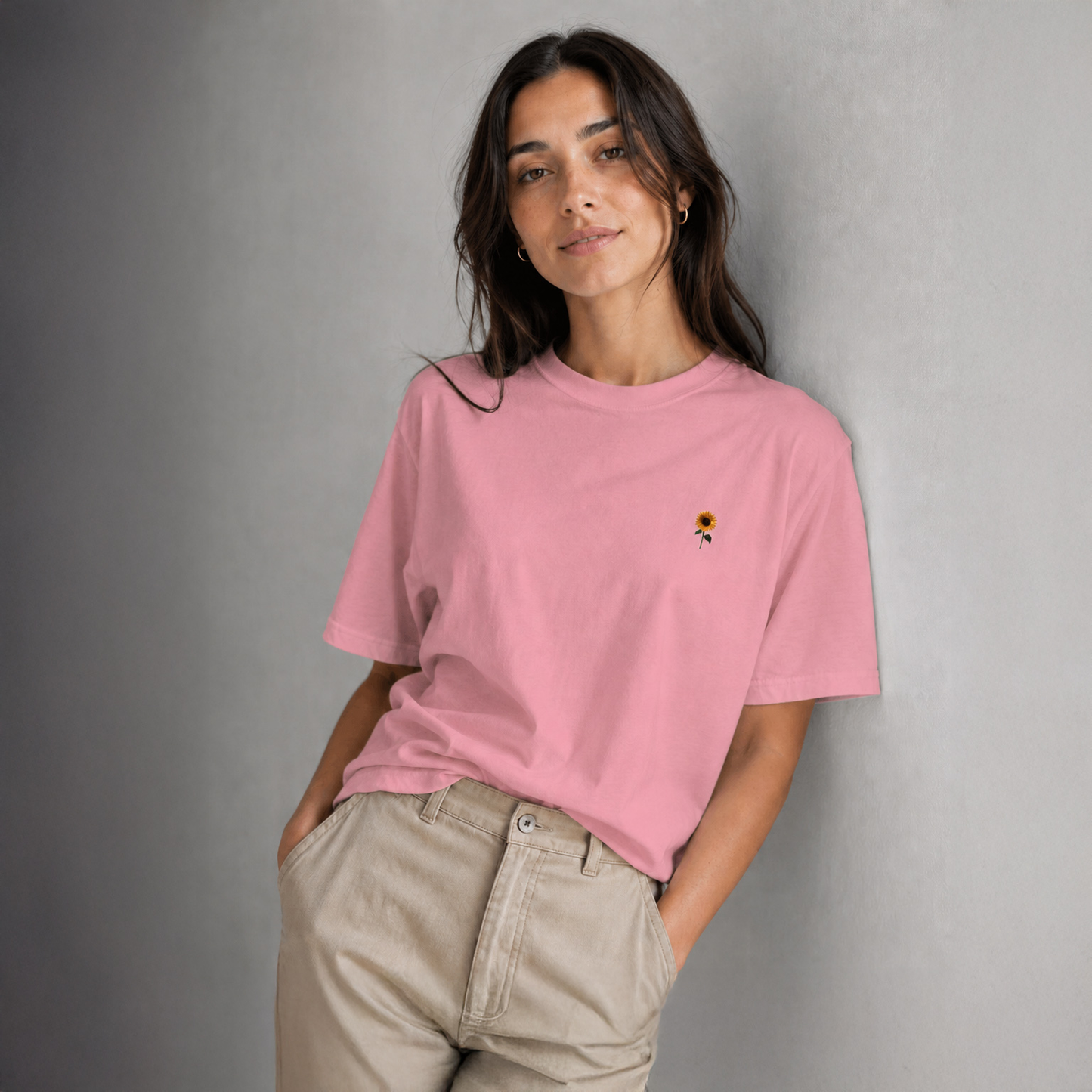 Woman wearing a pink t-shirt with a small design on a gray background
