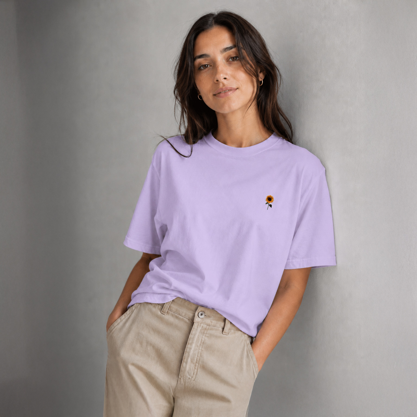 Woman wearing a lavender t-shirt with a small graphic on a gray background
