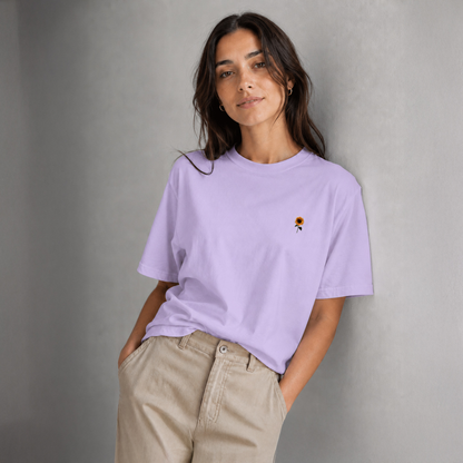 Woman wearing a lavender t-shirt with a small graphic on a gray background