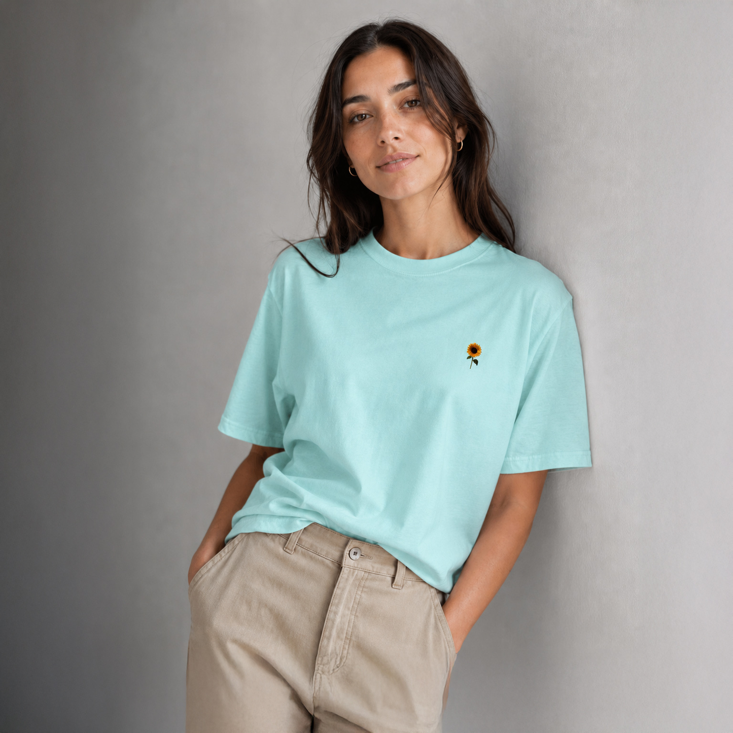 Woman wearing a light blue t-shirt with a small graphic on a gray background