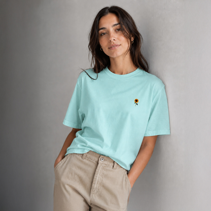 Woman wearing a light blue t-shirt with a small graphic on a gray background